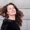 Thumbnail: Portret Klittebel purper paars glans groot huggies goudkleurig zwarte  trui zwaaiend haar