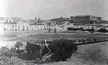 Vila Viçosa, Rossio de Baixo nos anos 20, ainda com um pontão sobre o curso de água que o atravessava. (A frente urbana é a definida pela Cerca Nova feita construir por D. Jaime no sec XVI, em fundo ao alto ainda bem visível a Fortaleza Nova de D Jaime e os terraços das fortificações do século XVII protagonista da resistência ao cerco que antecedeu a Batalha de Montes Claros)