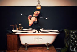 a woman performing a split on a bathing tub