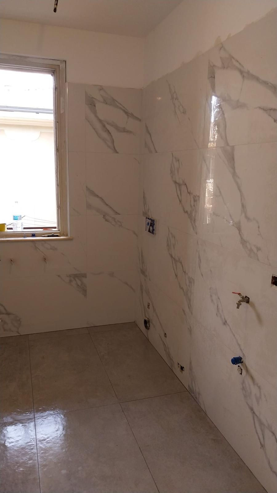 Bagno ristrutturato con nuovi rivestimenti in gres effetto marmo, pavimento moderno e pred