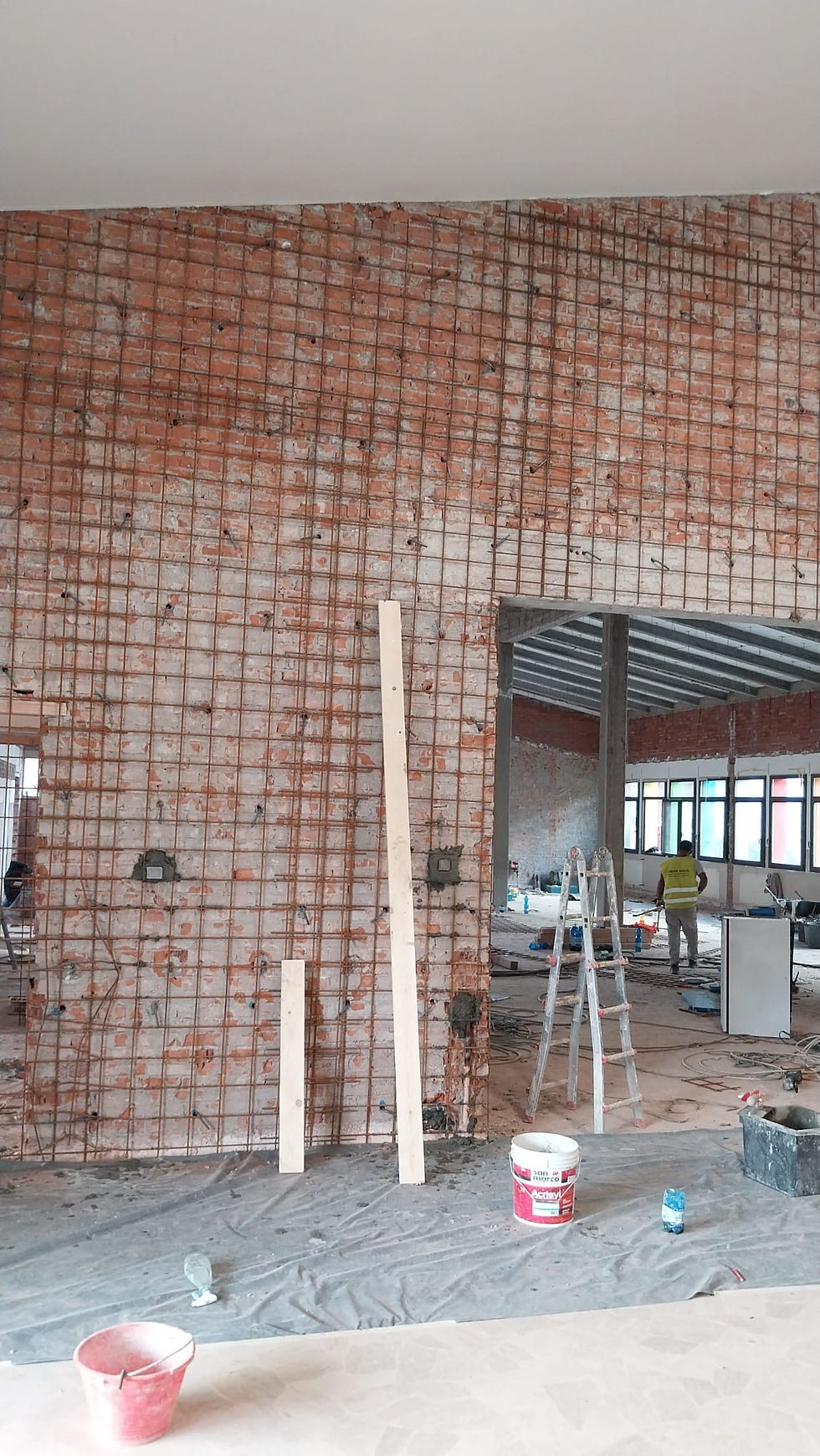 Parete interna con rete elettrosaldata applicata per il consolidamento e preparazione alla