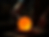 artist blowing molten orange glass sphere in dark studio.png