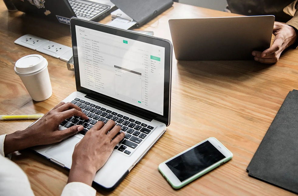 Thumbnail: Person typing on laptop during a business meeting with coffee and phone.