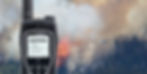 Iridium PTT satellite phone with wildfire and helicopter in background.