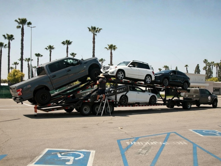 Car hauler strapping vehicles on the trailer