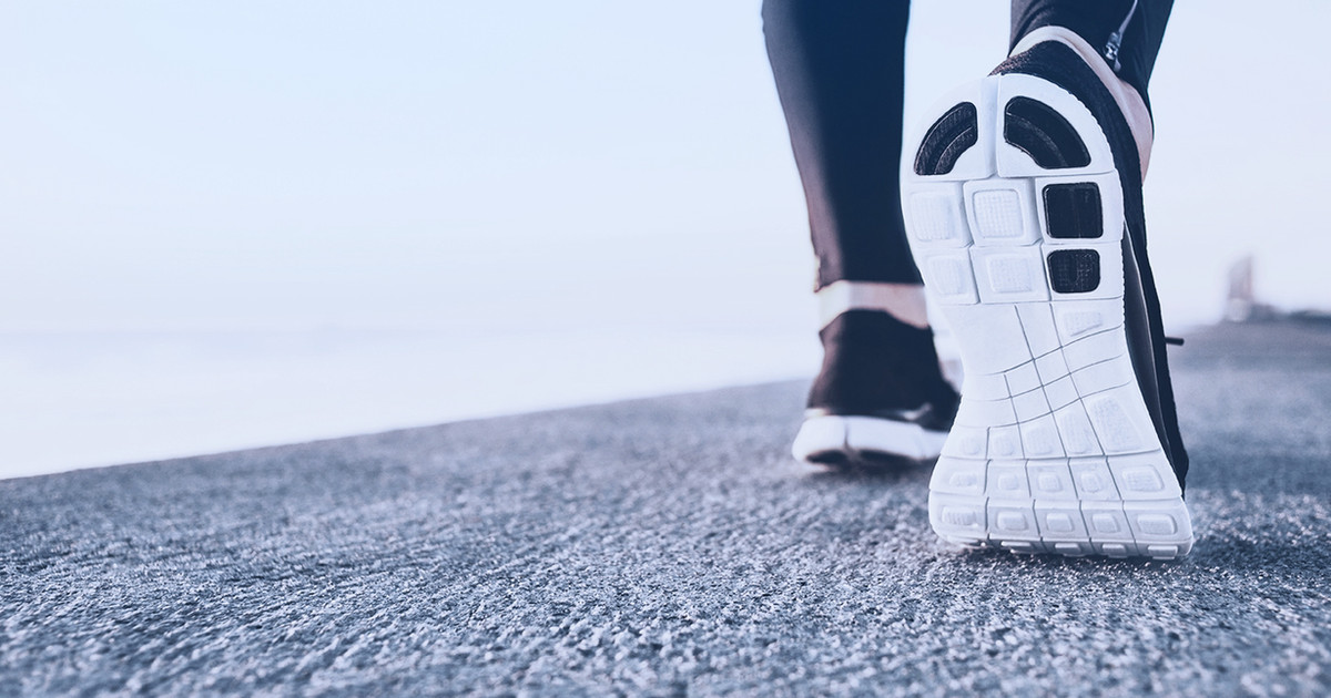 A person confidently walking outdoors while gradually rebuilding strength, balance and mobility after living with persistent pain.