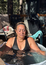 Woman meditating in an outdoor cold plunge tub