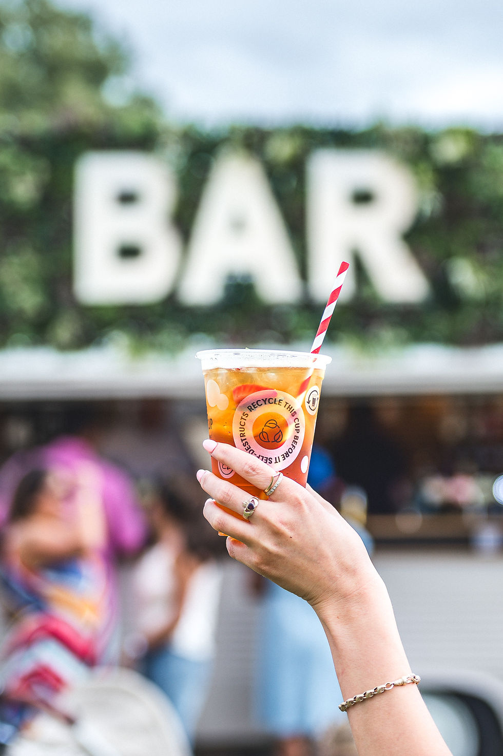 Festival drink held in front of the Vanderbar mobile bar signage