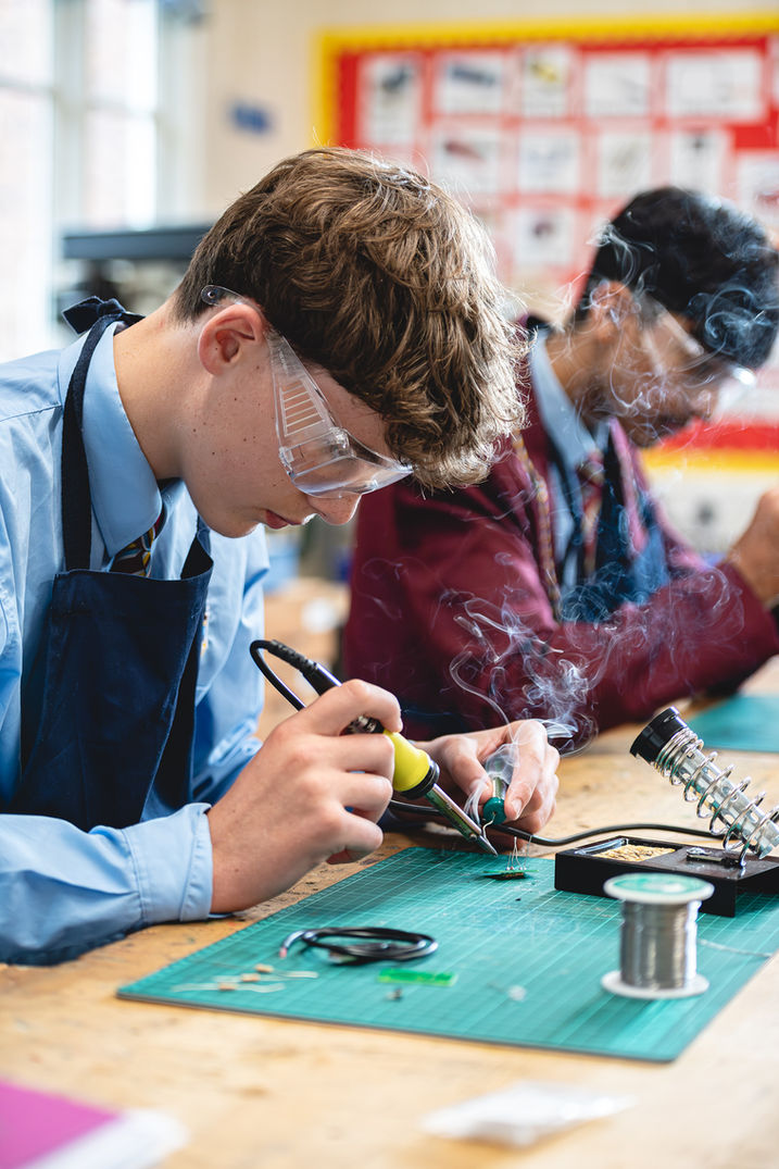 Two senior school boys sat in design technology lesson