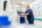 A doctor and nurse look on a computer together on a hospice ward; captured by PR photographer Aaron Scott Richards