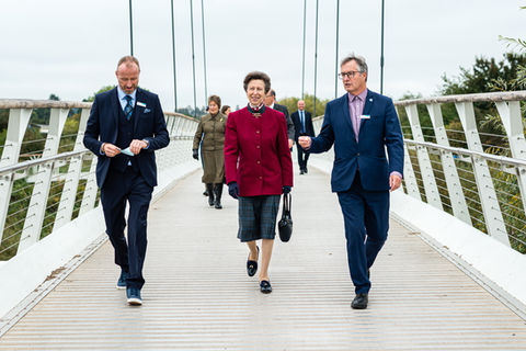 PR and event photography of Princess Anne wearing a beautiful burgundy jacket as she walks across the millennium way bridge for a Canal and Rivers Trust event in Worcestershire