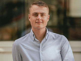 Man in blue striped shirt leaning on a stone balustrade for a business portrait in Birmingham