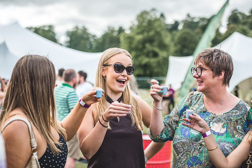Festival visitors laughing and enjoying drinks beside the Vanderbar mobile bar