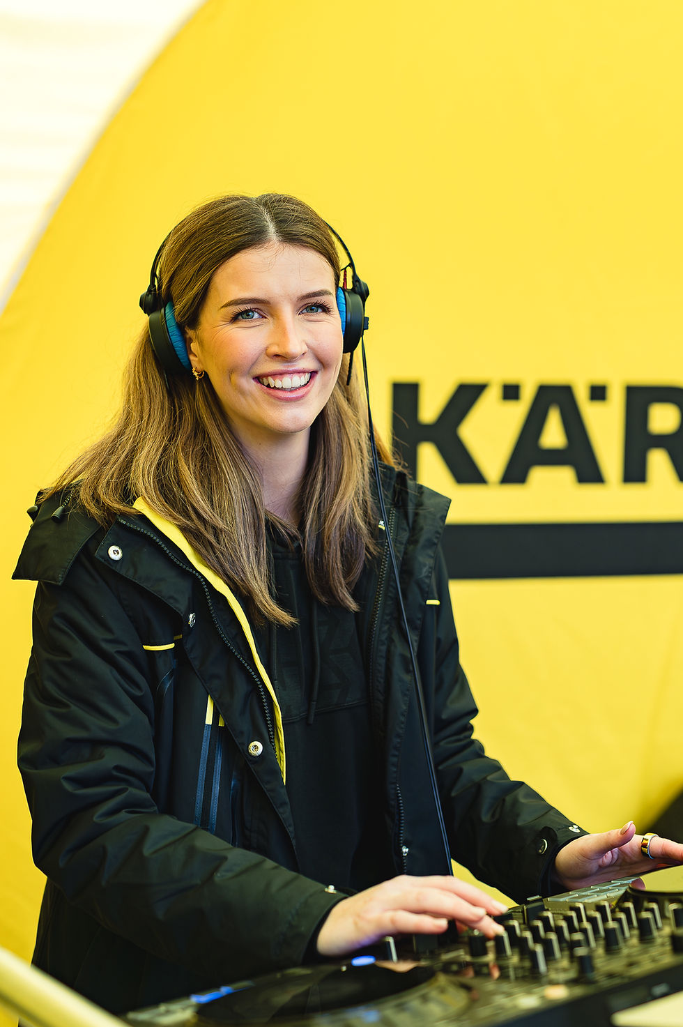 DJ performing in front of Kärcher branding during a commercial sales event at Woodland Grange