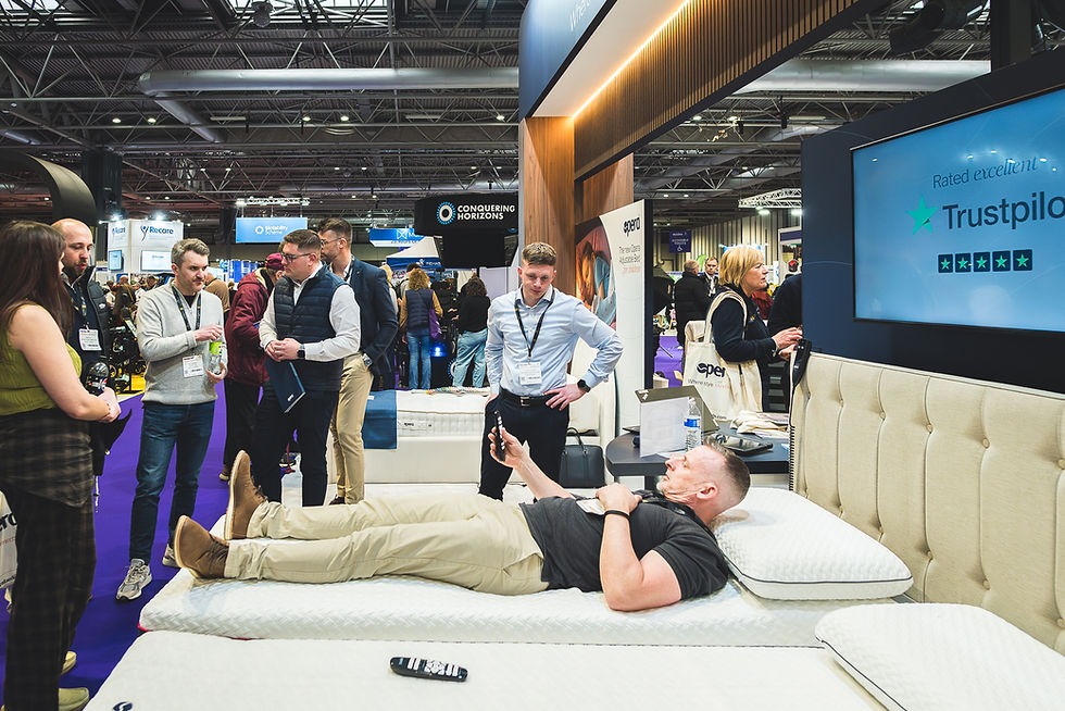 Visitors interacting with Opera Beds products at Naidex 2026 at the NEC Birmingham