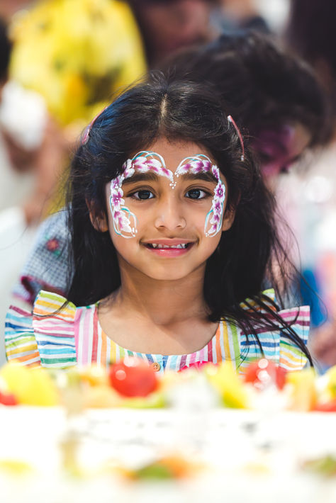 Child with colourful face paint at a birthday party