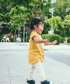 Toddler Girl Chasing Bubbles