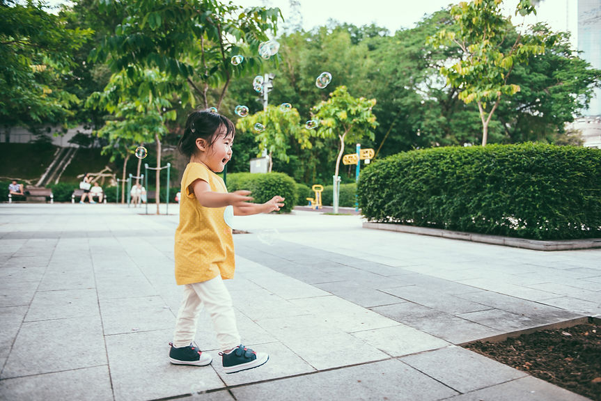 Toddler Girl Chasing Bubbles