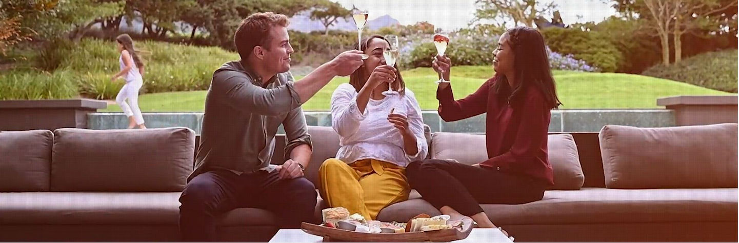 Relaxed moment with friends over a drink at vineyard