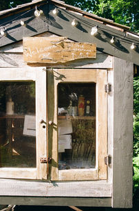 Tiny outdoor pantry labeled “Welcome to the Treehouse,” stocked with supplies inside.