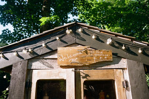 Tiny outdoor pantry labeled “Welcome to the Treehouse,” stocked with supplies inside.