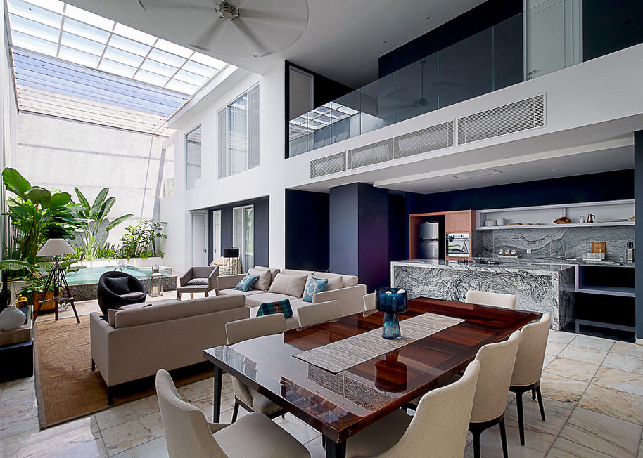 Overview of a luxury open-plan living room with high ceilings, dining table, and modern sofas.