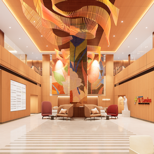 Spacious, modern hospital lobby with light wood-paneled walls, marble floors with a striped central pattern, and escalators on both sides. A large sculpture of an orange, wave-like wooden ceiling light hangs overhead above a central seating area with plush armchairs in beige and red. In the background, vibrant floral wall panels anchor the admission area near the "St. Carolus" branding on the wall.