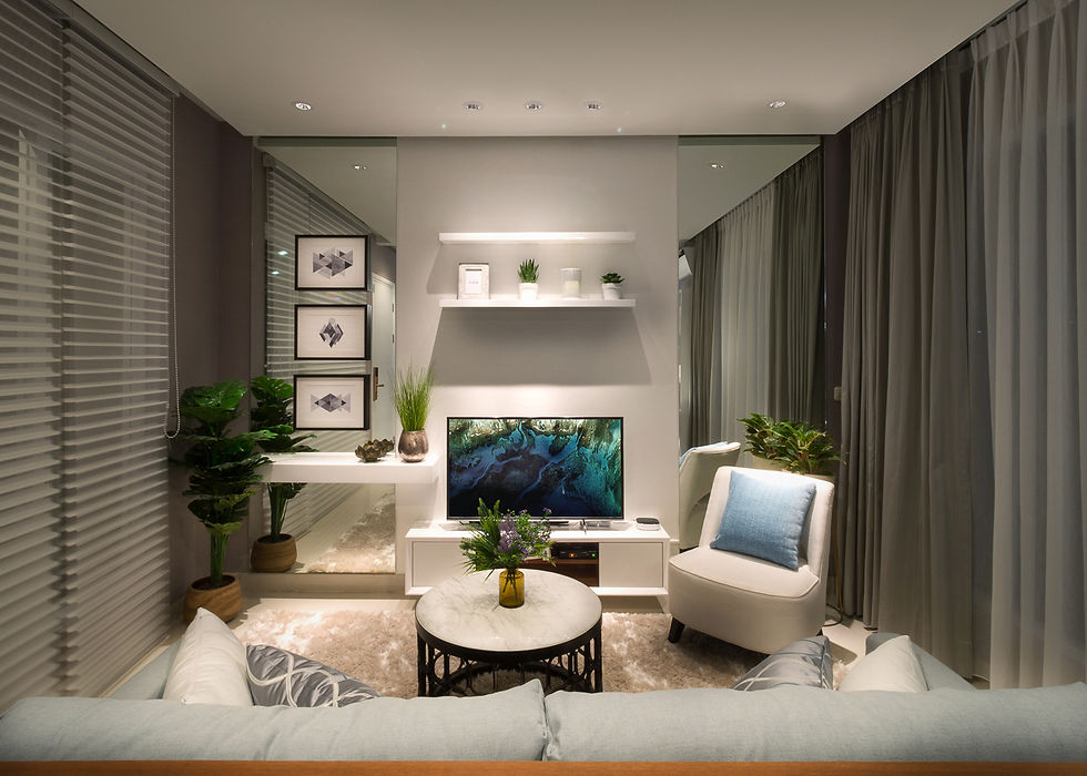 Cozy modern living room with TV, blue armchair, sofa, plants, shelves, and sheer curtains in a soft neutral, calm setting