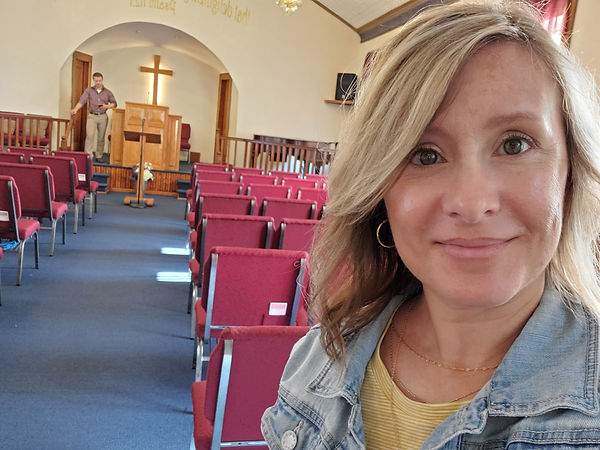 a pastor's wife takes a snap shot in the old church sanctuary
