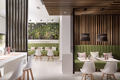 Inside one of this hotel's restaurants, you find floating green sofas sitting in front of modern wallpaper adorned walls; neutral multi-tone stripes, foliage etc.  Small white stools sit opposite the green sofas. 