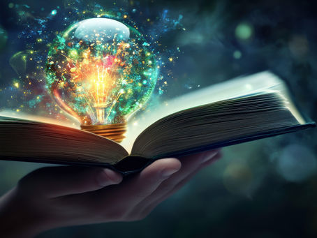 a book opened with a colorful, inspirational light bulb coming out of it. 