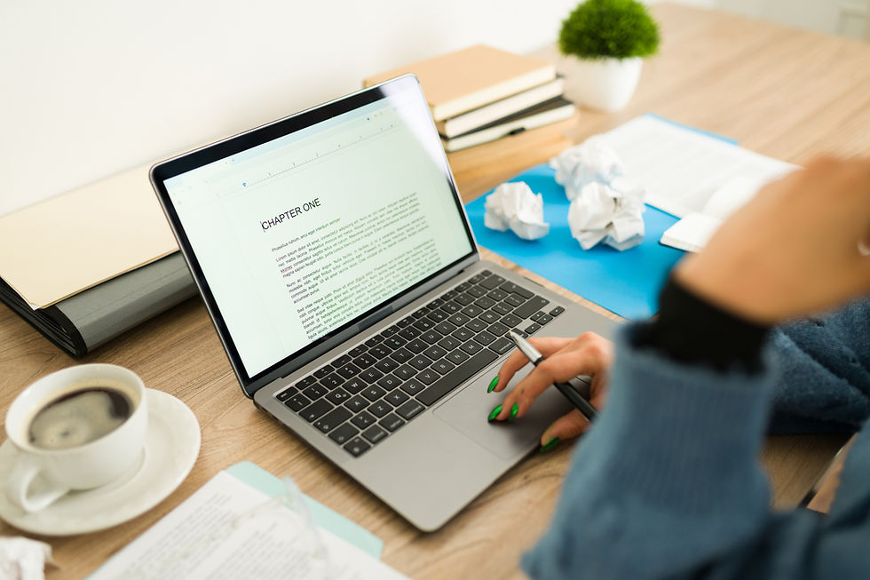 woman writing down plans on a computer with coffee and crumpled up paper next to her