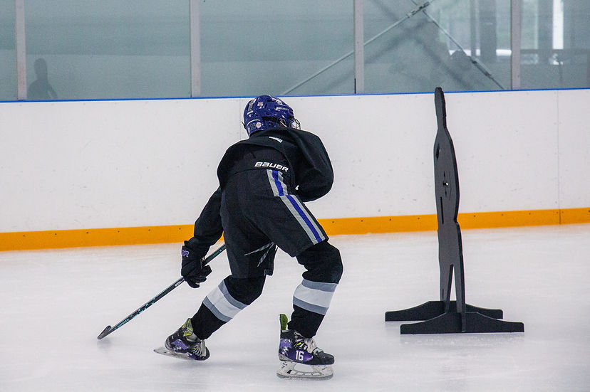 Close-up view of hockey skates on ice during practice