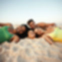 pretty people lying in the sand heads together happy, some athletes .jpg