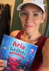 "Kristy Magee holding her book, Aria the Axolotl"