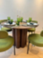 Olive green upholstered dining chairs with dark timber table in an Elephant & Castle London show home.