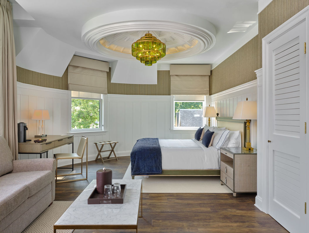 A photo of the interior of the northport hotel showing a bedroom with beige and olive green accents.