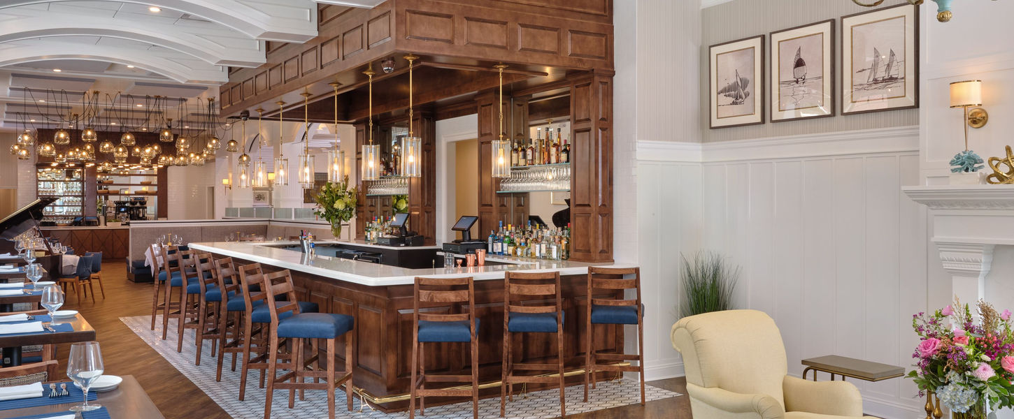 A photo of the interior of the northport hotel showing a wood panneled bar with high-top bar chairs.