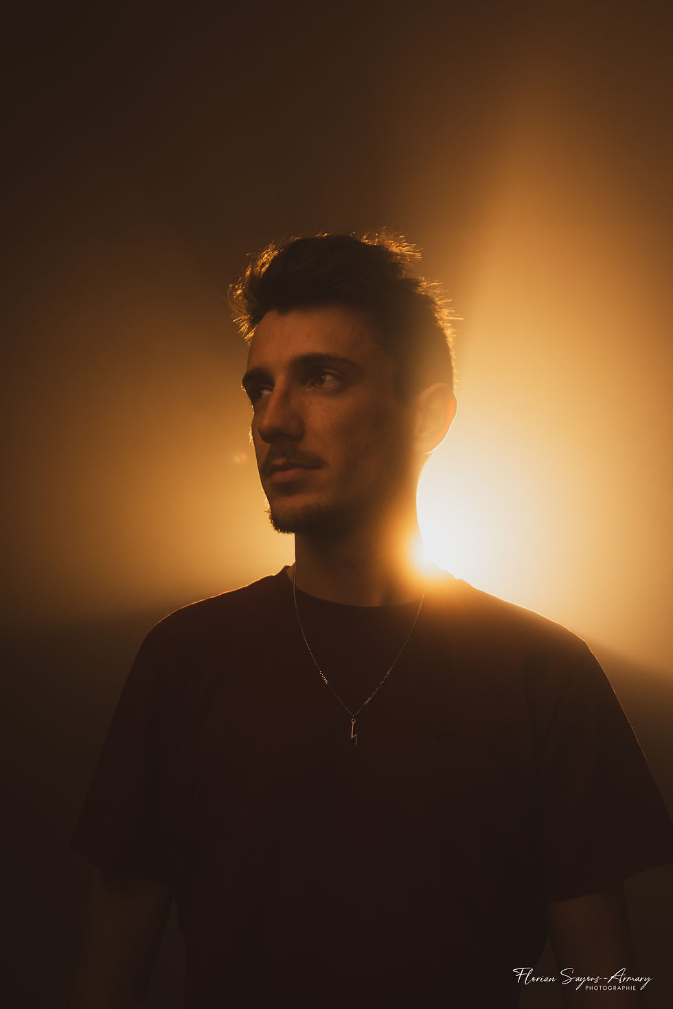 Portrait d'un homme dans un endroit sombre avec une lumière artificielle en contre jour