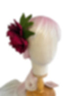 Large burgundy peony hair clip on a mannequin head with pink hair front view. white background