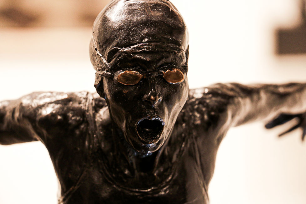 Screaming humanoid sculpture with raised arms – expressive art installation in bronze