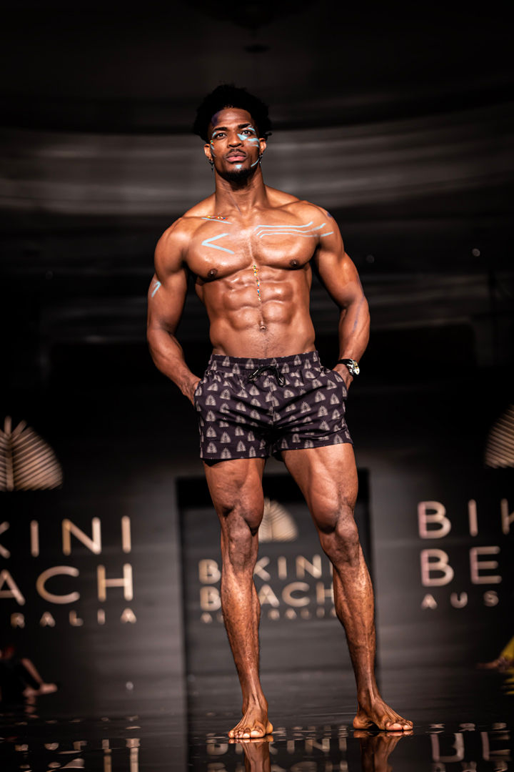 Male model with defined muscles in boxer-style swim trunks – strength and elegance