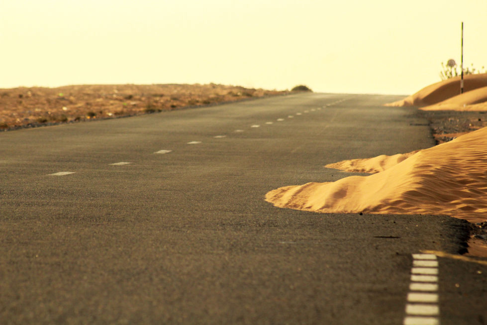 Long empty road cutting through the desert – solitude, silence, and endless horizon