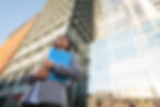 low-angle-businesswoman-holding-clipboard-city.jpg