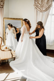mother of bride helping put wedding gown on
