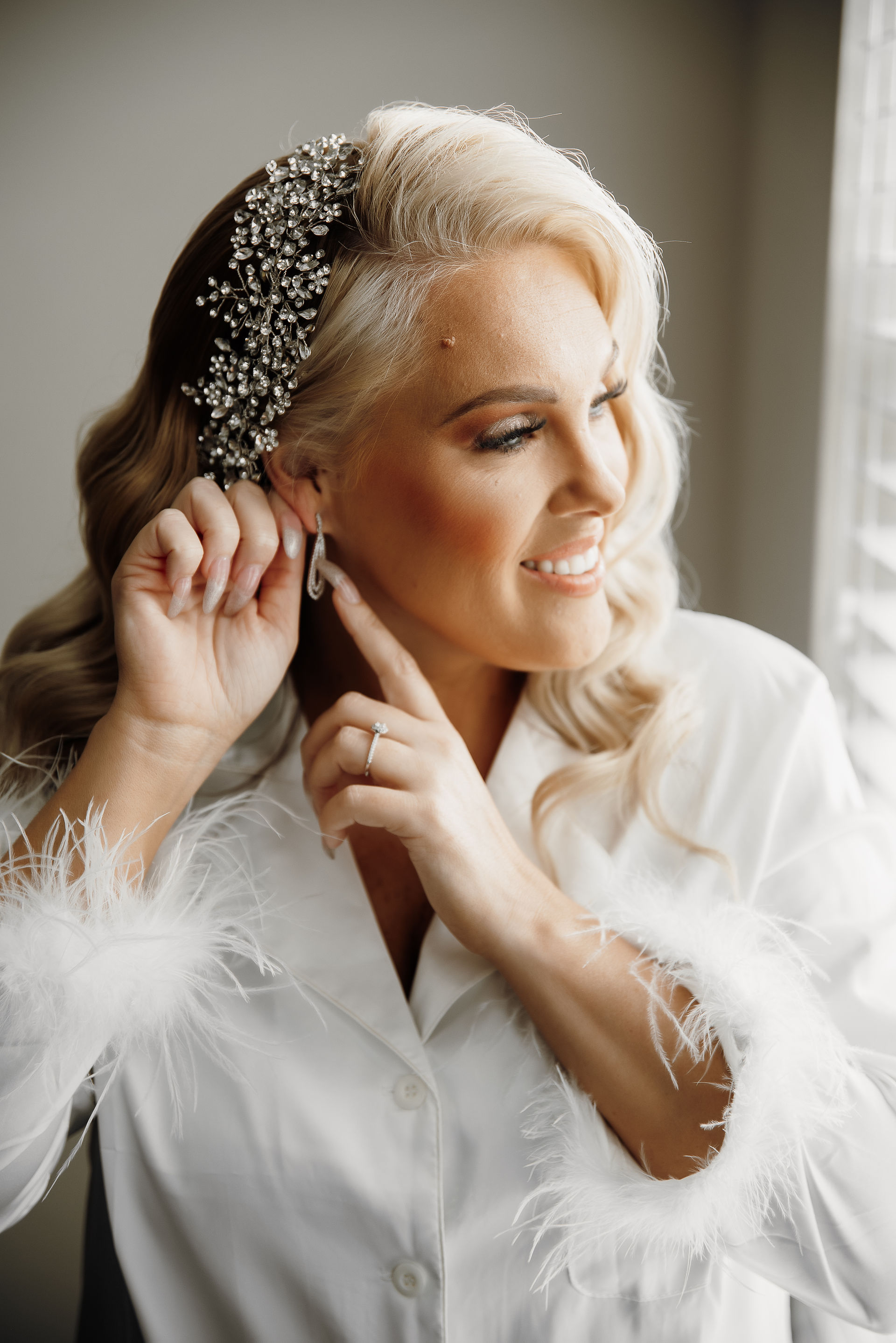 bride putting earrings on