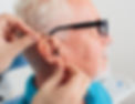 audiologist fitting hearing aid to the patient - hearing now london south.jpg