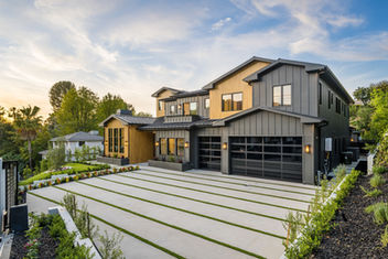 a contemporary home with a concrete driveway in front of them