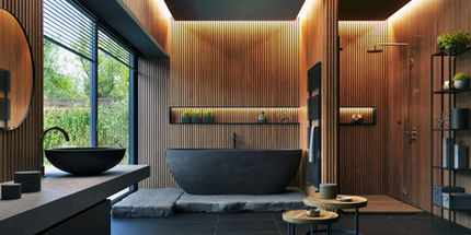 a bathroom with wood paneling and a black tub