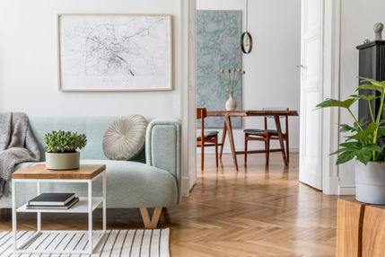 a living room with a blue couch and a map on the wall